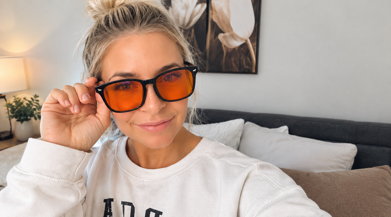 Lauren Bruun, founder of RADDHealth, wearing Ra Optics Maxwell Daylight blue light blocking glasses at home