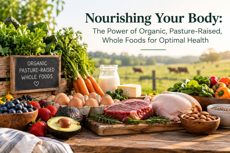 Organic, pasture-raised whole foods including vegetables, eggs, meat, and dairy on a wooden table with a farm field in the background